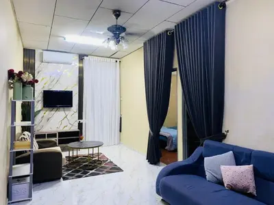 a living room with a blue couch and a tv at laman terrace stays in Sungai Petani