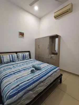 a bedroom with a bed with a blue comforter at Bertam Wawasan Homestay in Kepala Batas