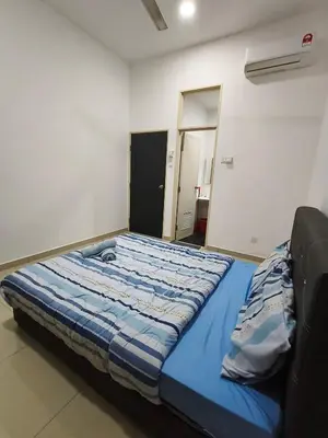 a bed in a room with a blue comforter at Bertam Wawasan Homestay in Kepala Batas