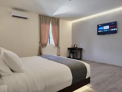 a bedroom with a bed with a tv on the wall at The Great Hotel Sri Iskandar in Seri Iskandar