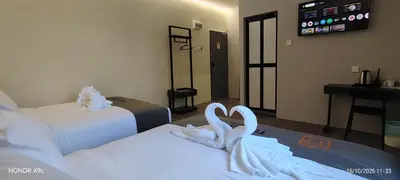 two swans are sitting on two beds in a hotel room at The Great Hotel Sri Iskandar in Seri Iskandar