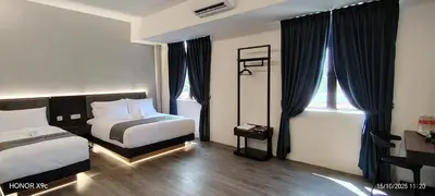 a hotel room with two beds and a window at The Great Hotel Sri Iskandar in Seri Iskandar