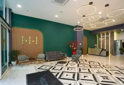 a lobby with a couch and chairs and a green wall at ICC Suites Ipoh City Center, New & cozy, 6 Pax in Ipoh