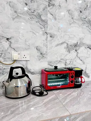 a red microwave sitting on the floor next to a tea kettle at \u9003\u79bb\u57ce\u5e02 mumu home in Gopeng