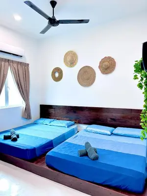two beds in a bedroom with a ceiling fan at \u9003\u79bb\u57ce\u5e02 mumu home in Gopeng