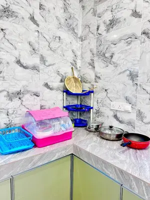 a kitchen counter with a pink tray and some pans at \u9003\u79bb\u57ce\u5e02 mumu home in Gopeng