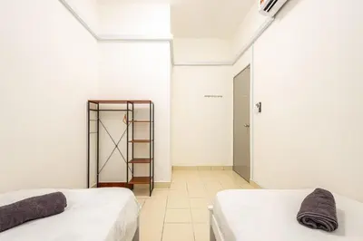 two beds in a white room with a mirror at O-Homestay at Falim 2 parking Mus lim friendly in Ipoh