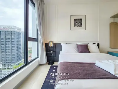 a bedroom with a bed and a large window at 22 Macalisterz George Town by Wodages in George Town