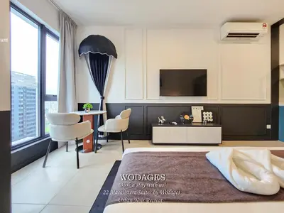 a bedroom with a bed and a desk and a tv at 22 Macalisterz George Town by Wodages in George Town