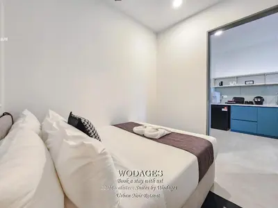 a white bedroom with a bed and a kitchen at 22 Macalisterz George Town by Wodages in George Town
