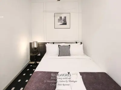 a bedroom with a white bed with a black and white pillow at 22 Macalisterz George Town by Wodages in George Town