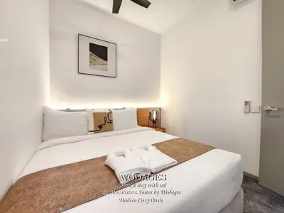 a white bedroom with a large bed with white sheets at 22 Macalisterz George Town by Wodages in George Town