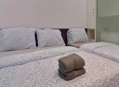 a bedroom with two beds with towels on them at H2H - Welcome Home - Majestic Ipoh - 5pax in Ipoh
