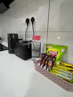 a basket of chips and snacks on a kitchen counter at Cozy Modern Condo with Pool & City Access in Bayan Lepas