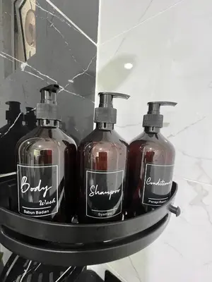 three bottles of soap on a shelf in a bathroom at Cozy Modern Condo with Pool & City Access in Bayan Lepas