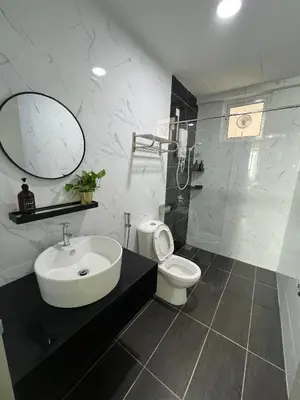 a bathroom with a sink and a toilet and a mirror at Cozy Modern Condo with Pool & City Access in Bayan Lepas