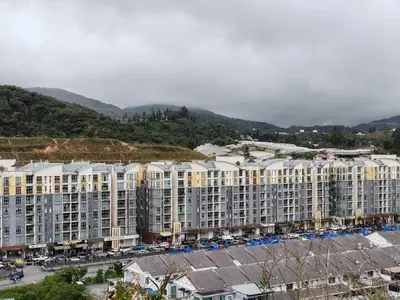a large apartment building in a city with mountains at Studio BARRINGTON SQUARE II in Brinchang