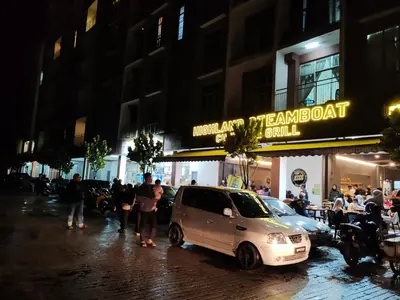a white car parked on a street at night at Studio BARRINGTON SQUARE II in Brinchang