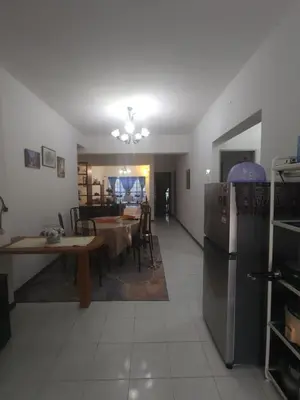 a kitchen and dining room with a table and a refrigerator at Nina's Apt Parkview CH in Tanah Rata