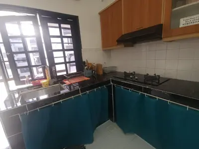 a kitchen with black counter tops and blue curtains at Nina's Apt Parkview CH in Tanah Rata