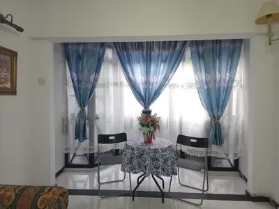 a room with a table and chairs and a window at Nina's Apt Parkview CH in Tanah Rata