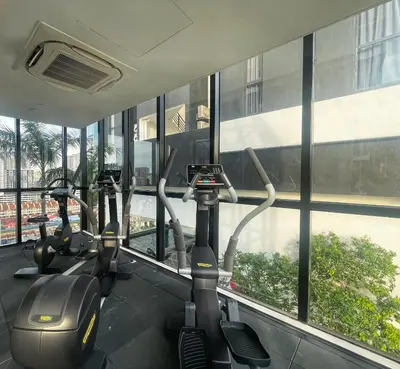 a row of exercise bikes in a gym with windows at SeaView Premium Family Suite 3B2R in George Town