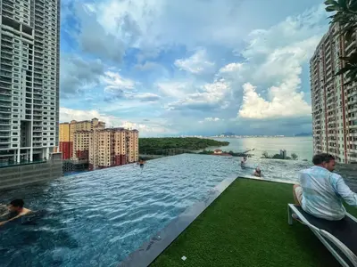 a infinity pool on a building with people in the water at SeaView Premium Family Suite 3B2R in George Town