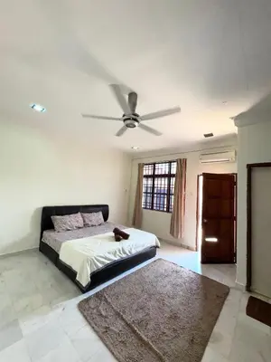 a bedroom with a bed with a ceiling fan at Ribat Homestay in Gerik