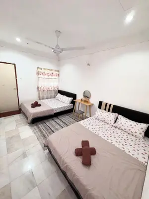 a bedroom with two beds and a cross on it at Ribat Homestay in Gerik
