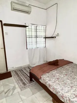 a bedroom with a bed and a window at Ribat Homestay in Gerik