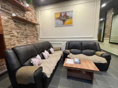 a living room with a leather couch and a table at GURNEY DRIVE Family-friendly Cozy Retreat 2-6 pax in George Town