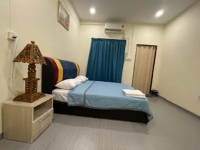 a bedroom with a bed and a table with a lamp at GURNEY DRIVE Family-friendly Cozy Retreat 2-6 pax in George Town
