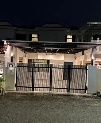 a white house with a gate in front of it at Taman Bagan Homestay in Butterworth