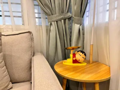 a table with a toy on it next to a chair at The Crayon Shin-chan Themed Stay Family Ipoh By LUX SUITE in Ipoh