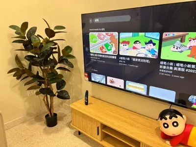 a flat screen tv in a living room with a plant at The Crayon Shin-chan Themed Stay Family Ipoh By LUX SUITE in Ipoh