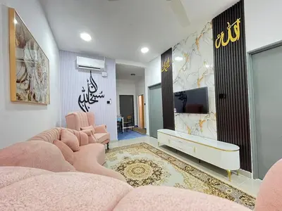 a living room with pink furniture and a tv at RJ Homestay Bandar Utama Gua Musang in Gua Musang