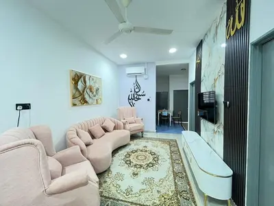 a living room with pink chairs and a couch at RJ Homestay Bandar Utama Gua Musang in Gua Musang
