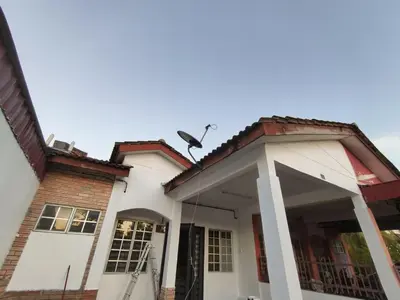 a white house with a large front porch at Nariz Homestay Kuala Ketil in Kuala Ketil