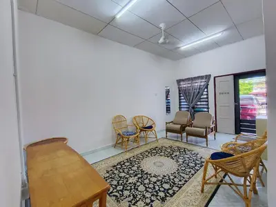 a living room with chairs and a table and a couch at Nariz Homestay Kuala Ketil in Kuala Ketil
