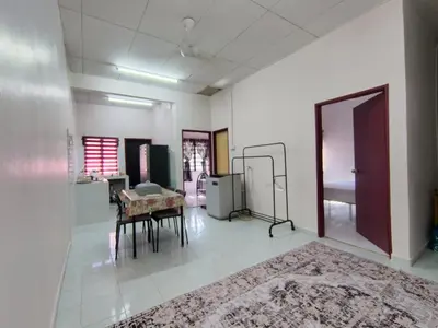 a living room with a table and a rug at Nariz Homestay Kuala Ketil in Kuala Ketil