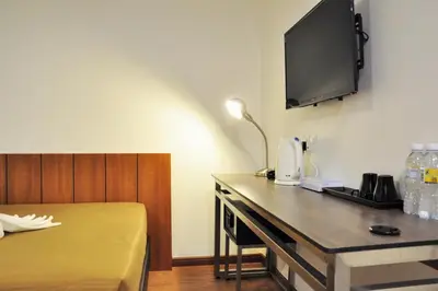 a room with a desk with a television on the wall at Urban Inn Kulim in Kulim