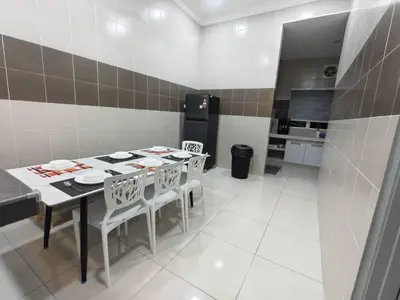 a kitchen with a table and chairs and a refrigerator at Hello Pangkor Home 77 - A Nest for 15 buddies in Pangkor