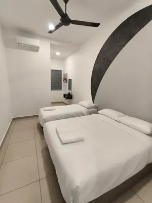 two beds in a room with a ceiling fan at Hello Pangkor Home 77 - A Nest for 15 buddies in Pangkor