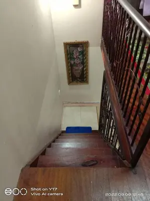 a staircase with a blue mat on the floor and a picture at Homestay Bedong Teratak Kasih in Gua Sai