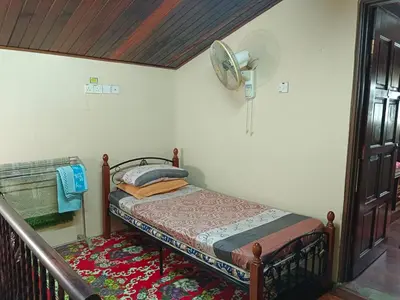 a bedroom with a bed and a fan on the wall at Homestay Bedong Teratak Kasih in Gua Sai