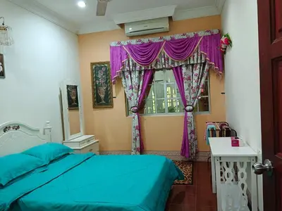 a bedroom with a bed and a window with purple curtains at Homestay Bedong Teratak Kasih in Gua Sai