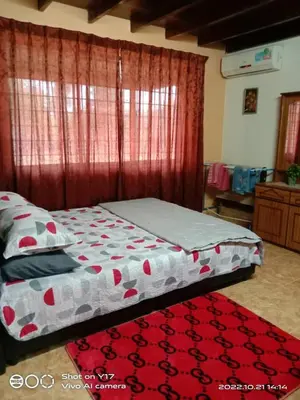 a bedroom with a bed and a red carpet at Homestay Bedong Teratak Kasih in Gua Sai