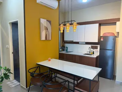 a kitchen with a table and a refrigerator at Nilai Mesahill Premier Deluxe Luxury Homestay,Mesamall in Gua Sai