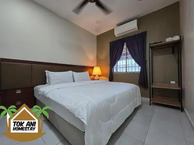 a bedroom with a large bed with a ceiling fan at Homestay Tok Ani by Ardzman Hospitality in Permatang Pauh
