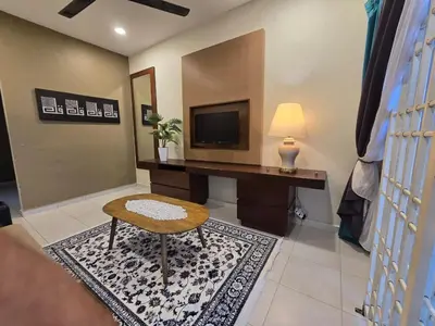 a living room with a desk and a television at Homestay Tok Ani by Ardzman Hospitality in Permatang Pauh